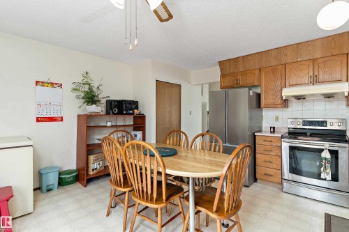 Spacious kitchen featuring stainless steel appliances, wood cabinetry with ample storage, and light wood-finish flooring - 17724 94 Street Nw, Edmonton, AB 