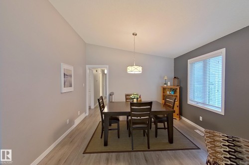 Dining area featuring wood-finish flooring, vaulted ceilings, and a contemporary pendant light fixture - 16 Brunswick Crescent, St. Albert, AB - Indoor Photo Showing Dining Room