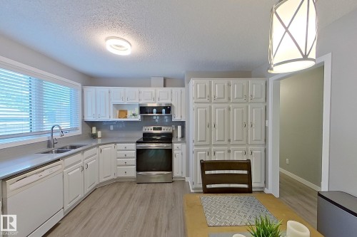Kitchen featuring white cabinetry, light gray countertops, and wood-finish flooring - 16 Brunswick Crescent, St. Albert, AB - Indoor Photo Showing Kitchen With Double Sink