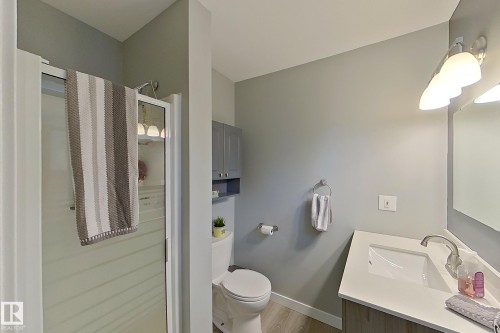 Bathroom featuring a glass-enclosed shower, wood-finish flooring, a contemporary vanity with an integrated sink, and an overhead light fixture - 16 Brunswick Crescent, St. Albert, AB - Indoor Photo Showing Bathroom
