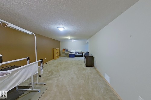 Spacious lower-level room featuring plush carpet flooring, recessed lighting, and a textured ceiling - 16 Brunswick Crescent, St. Albert, AB - Indoor Photo Showing Other Room