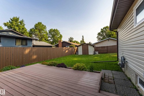 Expansive outdoor living area featuring a spacious composite deck, a large grassy yard, and a storage shed - 16 Brunswick Crescent, St. Albert, AB - Outdoor With Exterior