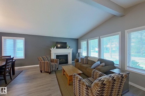 Open-concept living area featuring a vaulted ceiling and wood-finish flooring - 16 Brunswick Crescent, St. Albert, AB - Indoor Photo Showing Living Room With Fireplace