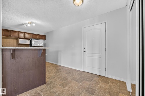 Kitchenette with wood-finish cabinetry, light-toned countertops, and tile flooring - #6430 7331 South Terwillegar Dr Nw, Edmonton, AB 
