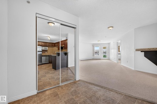 Mirrored sliding doors, carpet flooring, tile flooring, built-in shelving, and double doors - #6430 7331 South Terwillegar Dr Nw, Edmonton, AB 