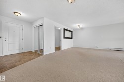 Entry with white paneled door, light-toned tile flooring, and mirrored closet doors - 