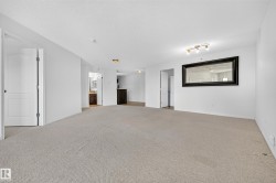 Neutral-toned carpet flooring, white walls, and track lighting - 