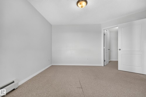 Neutral-toned carpeting, light gray walls, white baseboards, and a semi-flush mount ceiling light fixture - #6430 7331 South Terwillegar Dr Nw, Edmonton, AB 