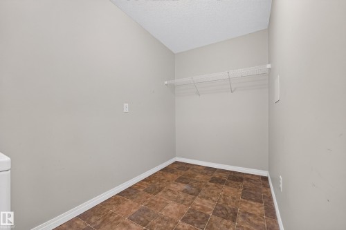 Utility room with tiled flooring and a wall-mounted wire shelf - #6430 7331 South Terwillegar Dr Nw, Edmonton, AB 