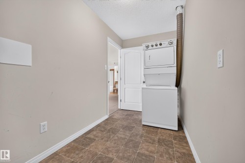 Integrated laundry appliances with white finishes, durable tile flooring, and neutral wall paint - #6430 7331 South Terwillegar Dr Nw, Edmonton, AB 