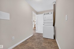 Integrated laundry appliances with white finishes, durable tile flooring, and neutral wall paint - 
