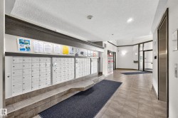 Building entrance featuring floor-to-ceiling glass doors, tile flooring, and integrated mailboxes - 