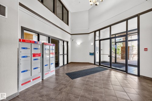 Foyer featuring tiled flooring, high ceilings, multiple transom windows, and built-in mailboxes - #6430 7331 South Terwillegar Dr Nw, Edmonton, AB 