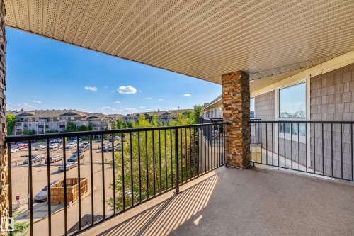 Spacious balcony with concrete flooring, stone-clad pillar, and black metal railing - #6430 7331 South Terwillegar Dr Nw, Edmonton, AB 