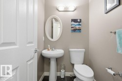 Pedestal sink with chrome faucet, oval mirror, and wall-mounted light fixture - 