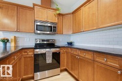 U-shaped kitchen with wood cabinetry and dark countertops - 