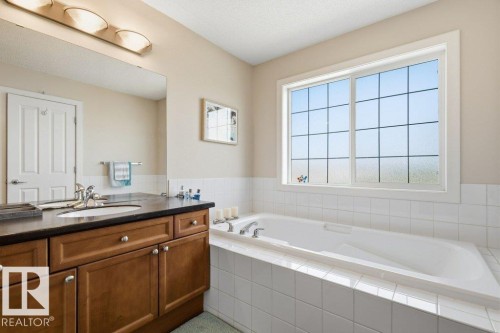 Deep soaking tub with white tile surround - #17 7293 South Terwillegar Dr Nw, Edmonton, AB - Indoor Photo Showing Bathroom