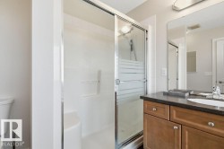 Walk-in shower with clear glass sliding doors and white tiled surround - 