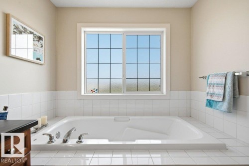 Soaking tub with chrome fixtures and white tiled surround - #17 7293 South Terwillegar Dr Nw, Edmonton, AB - Indoor Photo Showing Bathroom