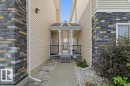Covered front entry featuring a gabled roofline, white support columns, and black railings - #17 7293 South Terwillegar Dr Nw, Edmonton, AB  - Outdoor 