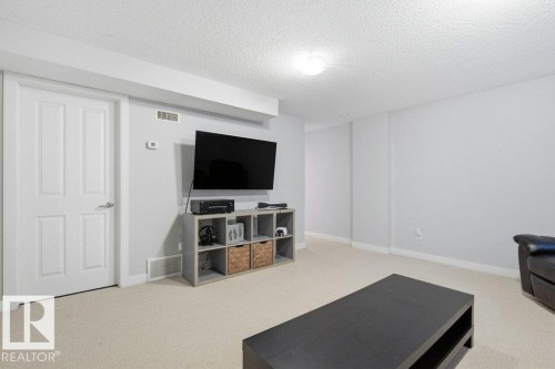 Spacious room featuring light-colored carpeting, white baseboards, and a neutral wall color - #17 7293 South Terwillegar Dr Nw, Edmonton, AB - Indoor