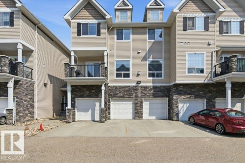Multi-level townhome featuring beige horizontal siding and stone veneer accents - #17 7293 South Terwillegar Dr Nw, Edmonton, AB - Outdoor With Facade