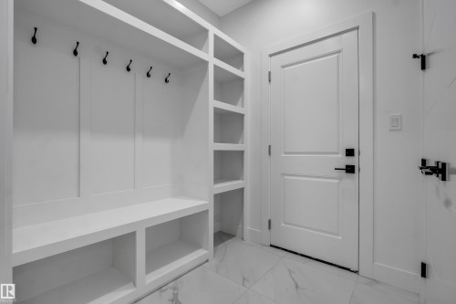 Built-in mudroom storage featuring multiple hooks, integrated shelving, and a seating bench - 4005 39 Street, Beaumont, AB - Indoor