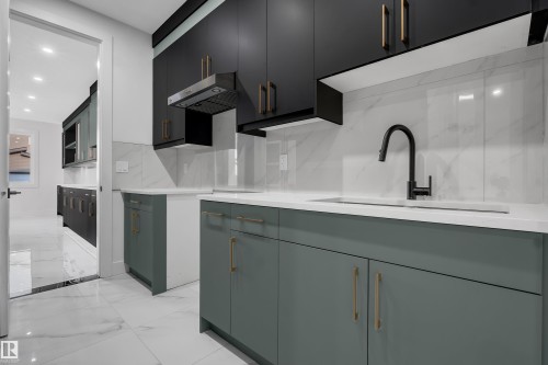 Modern kitchen featuring two-tone cabinetry with black upper cabinets and sage green lower cabinets - 4005 39 Street, Beaumont, AB - Indoor Photo Showing Kitchen With Upgraded Kitchen