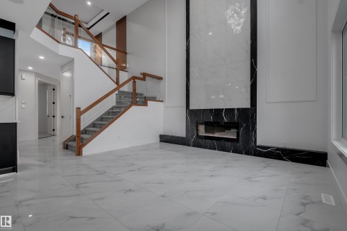 Spacious interior featuring large format marble-look tile flooring - 4005 39 Street, Beaumont, AB - Indoor Photo Showing Other Room
