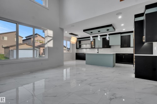 Spacious open-concept living area featuring large format polished tile flooring and a two-story ceiling - 4005 39 Street, Beaumont, AB - 