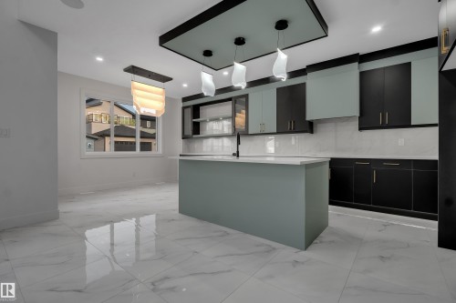 Contemporary kitchen with a central island, two-tone cabinetry, and large format tile flooring - 4005 39 Street, Beaumont, AB - Indoor Photo Showing Kitchen