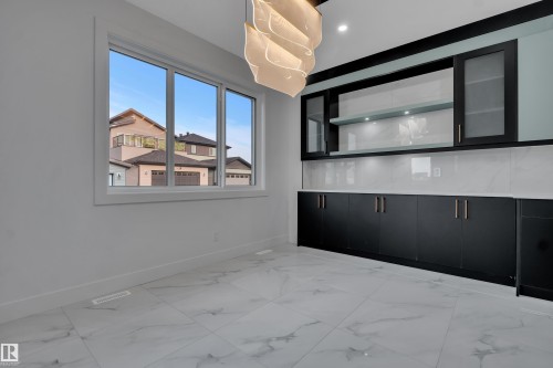 Bright interior space featuring a large window, white trim, and a contemporary ceiling fixture - 4005 39 Street, Beaumont, AB - Indoor Photo Showing Other Room