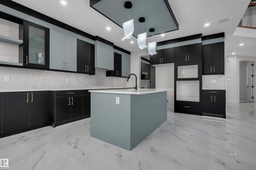 Modern kitchen featuring a central island, two-tone cabinetry, white countertops, and white tile flooring - 4005 39 Street, Beaumont, AB - Indoor Photo Showing Kitchen