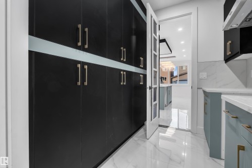 Extended pantry featuring full-height black cabinetry with brushed gold hardware and a light-toned accent band - 4005 39 Street, Beaumont, AB - Indoor