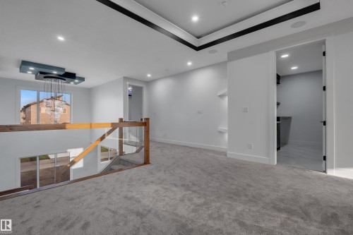 Upper-level landing featuring plush gray carpeting and a modern chandelier - 4005 39 Street, Beaumont, AB - Indoor Photo Showing Other Room