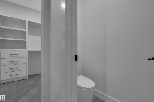 Integrated closet system featuring white shelving and drawers with brushed nickel hardware - 4005 39 Street, Beaumont, AB - Indoor