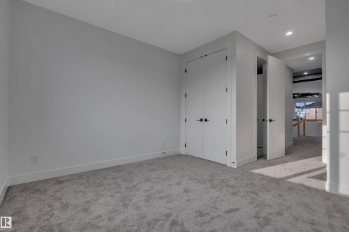 Room featuring light gray walls, gray carpeting, recessed ceiling lighting, and white bi-fold closet doors with matte black hardware - 4005 39 Street, Beaumont, AB - Indoor Photo Showing Other Room