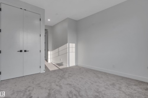 Carpeted room with recessed lighting and a contemporary closet featuring double doors with matte black hardware - 4005 39 Street, Beaumont, AB - Indoor Photo Showing Other Room