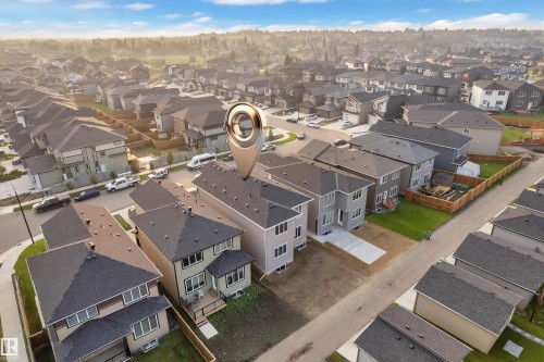 Aerial overview of a residential neighborhood featuring multiple single-family homes with gray shingle roofs, various exterior finishes, and established streets - 4005 39 Street, Beaumont, AB - Outdoor With View