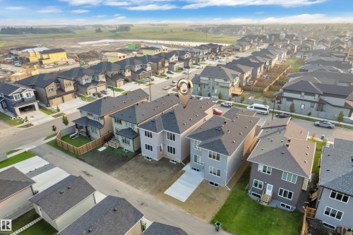 Newly constructed residential property featuring a gray exterior, dark shingle roof, and multiple windows - 4005 39 Street, Beaumont, AB - Outdoor With View