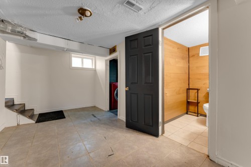 Lower level featuring tiled flooring, a utility sink, and a built-in toilet - 12116 81 Street Nw, Edmonton, AB 