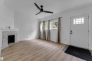 Light wood-finish flooring, white walls, and a decorative fireplace - 12116 81 Street Nw, Edmonton, AB 