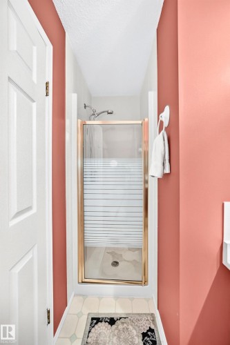 Shower with gold-toned frame, frosted glass door, and tiled enclosure - 4327 49 Street Nw, Edmonton, AB 
