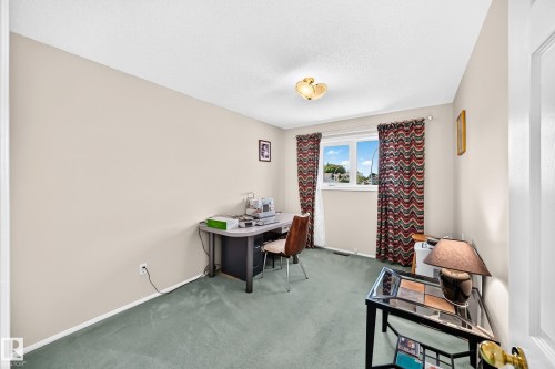 Neutral wall paint, carpeted flooring, window with natural light, and a ceiling-mounted light fixture - 4327 49 Street Nw, Edmonton, AB 