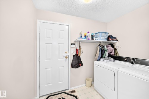 Dedicated laundry area with a utility shelf, hanging rod, and light-colored flooring - 4327 49 Street Nw, Edmonton, AB 
