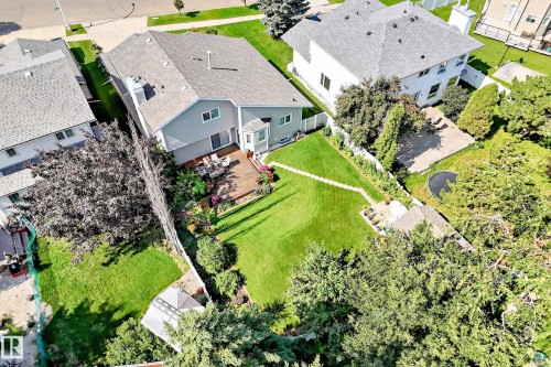 Expansive backyard with a manicured lawn, wood deck, and mature trees - 4327 49 Street Nw, Edmonton, AB 