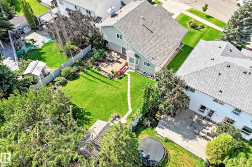 Expansive green lawn, multi-level composite deck, mature trees, wood privacy fencing, and a detached storage shed - 4327 49 Street Nw, Edmonton, AB 