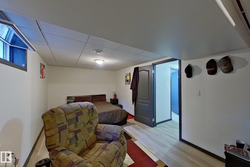 Finished basement recreation room featuring wood-finish flooring, recessed ceiling lighting, and ample space for multiple seating areas - 14 Brunswick Crescent, St. Albert, AB 