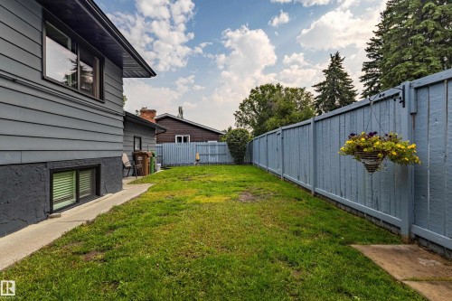 Expansive backyard featuring a manicured lawn, a concrete walkway, and a privacy fence - 14 Brunswick Crescent, St. Albert, AB 