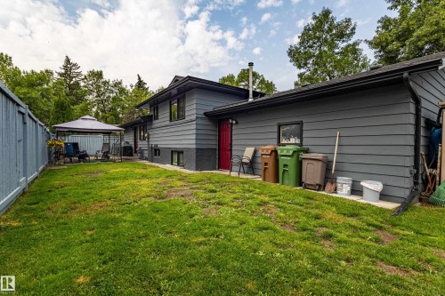 Expansive backyard with a manicured lawn, complete with a dedicated patio area, and a privacy fence - 14 Brunswick Crescent, St. Albert, AB 
